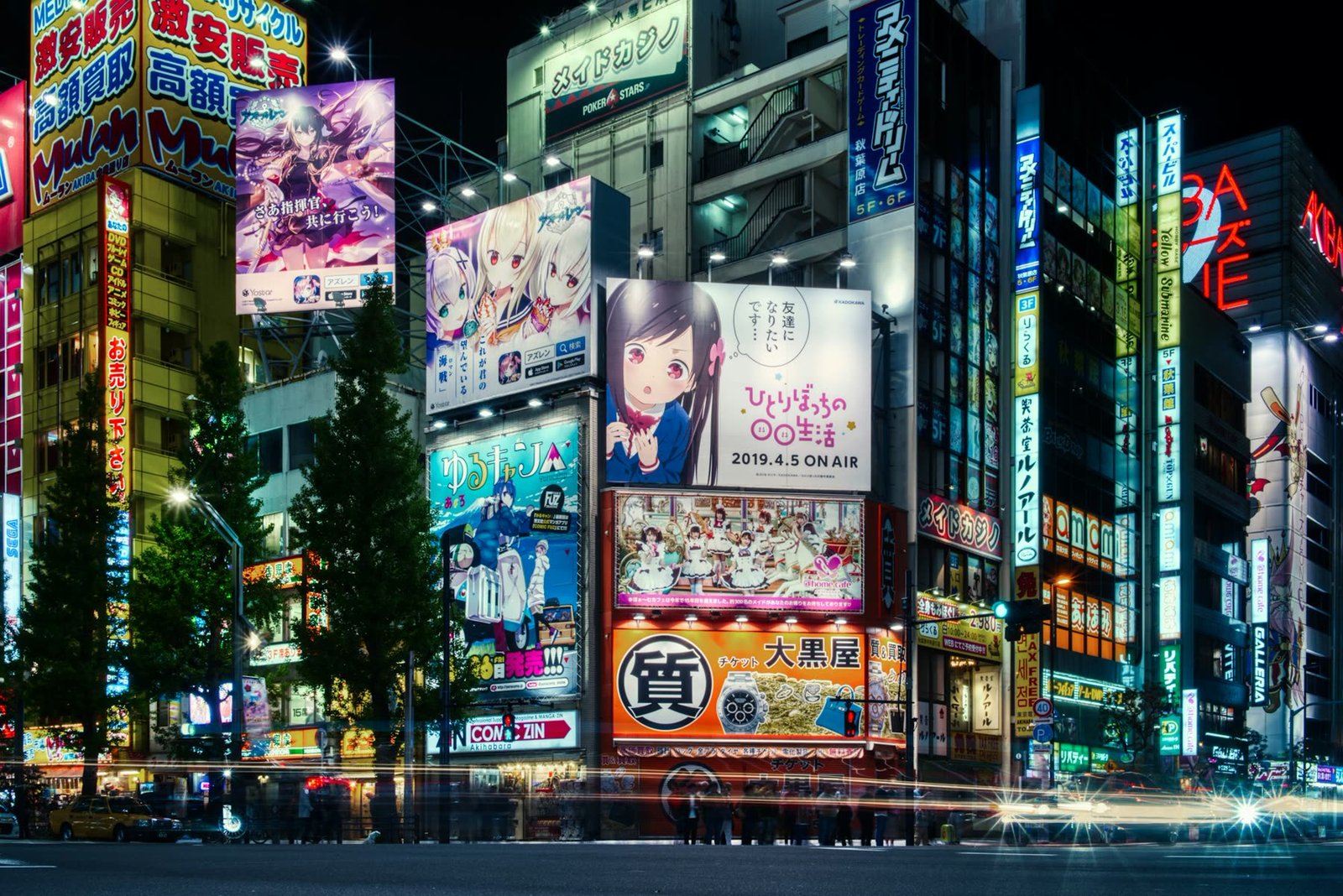 Akihabara at night, its buildings covered in anime billboards